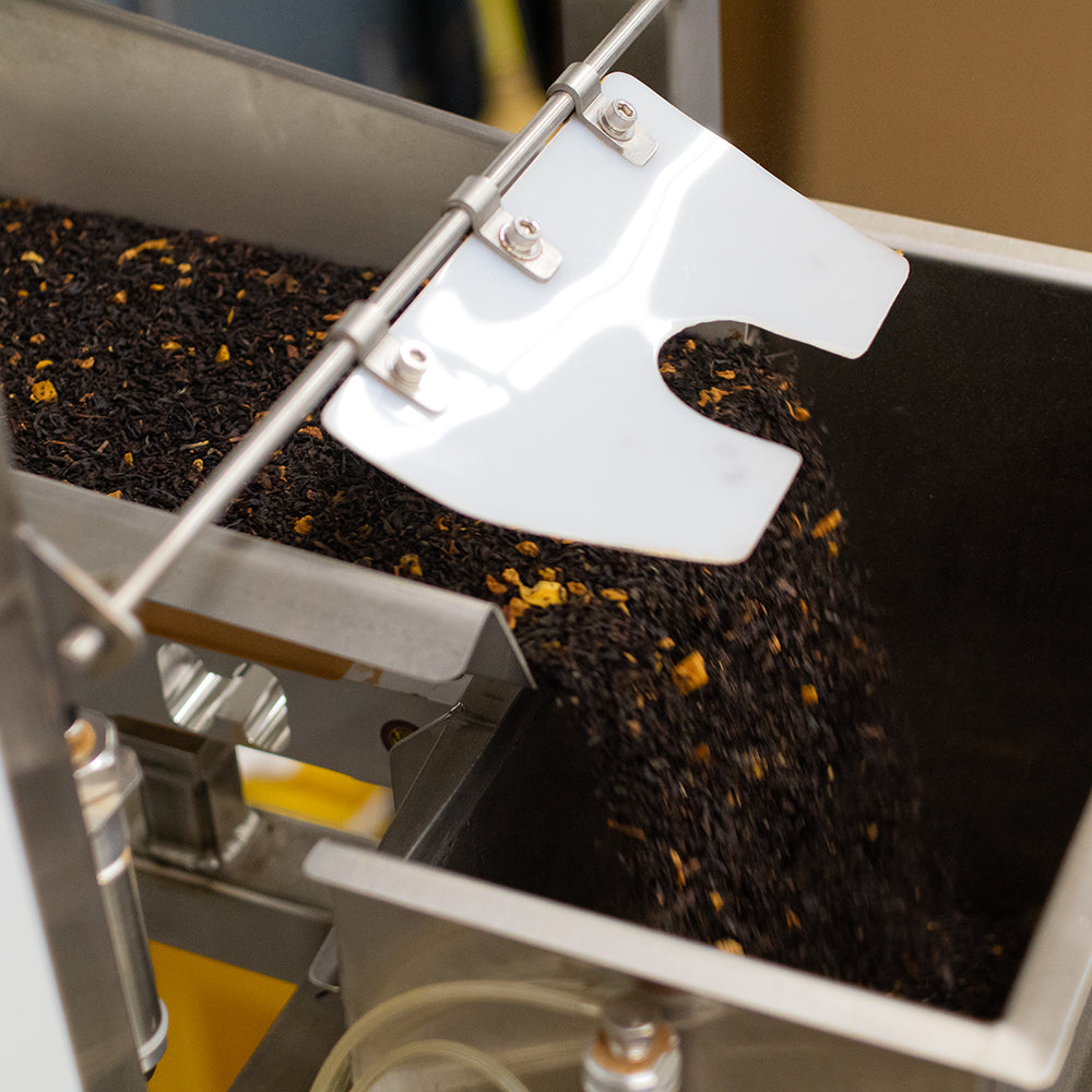 Loose-leaf black tea being portioned out for packing.