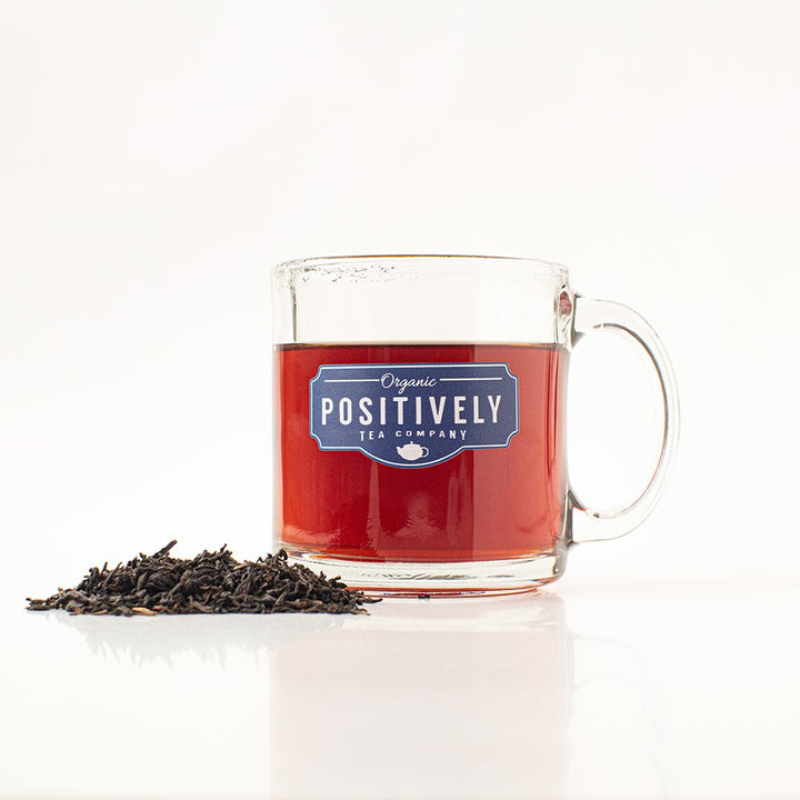 Freshly brewed cup of Organic Assam black tea from Positively Tea Company, showcasing a rich amber color and smooth aroma.
