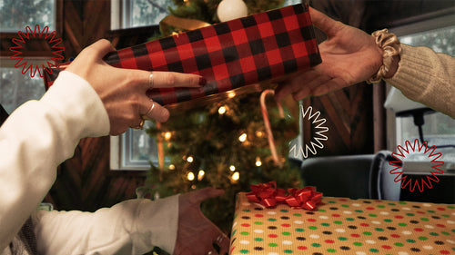 Two people exchanging wrapped gifts.