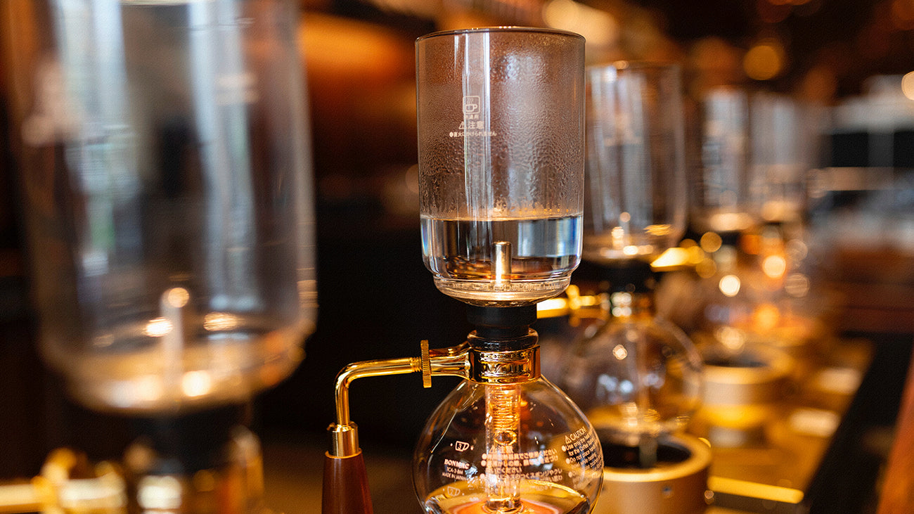 A row of siphon coffee brewers.
