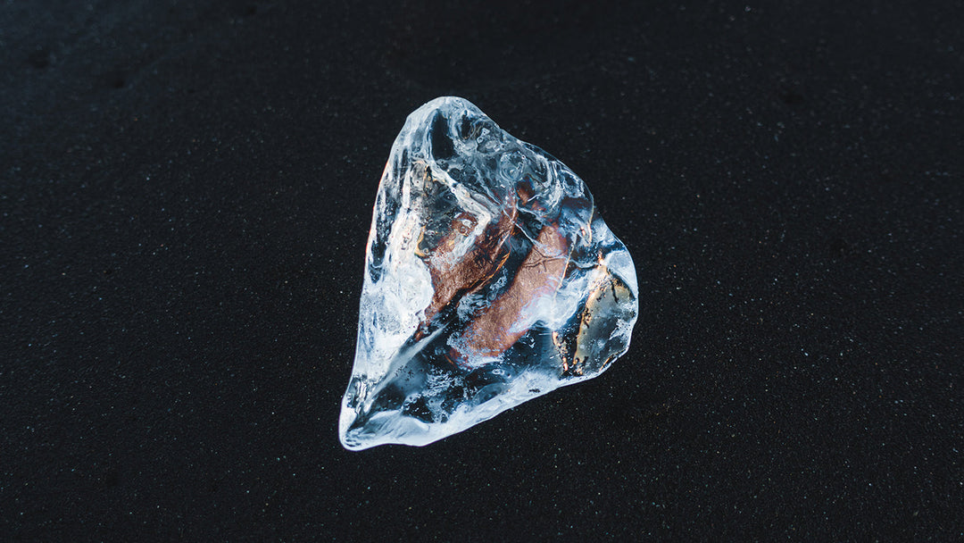 A single coffee bean frozen in ice.