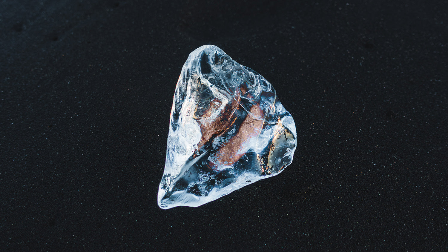 A single coffee bean frozen in ice.