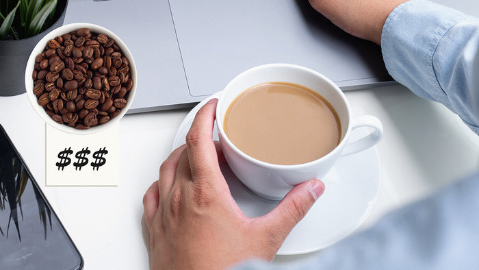 A coffee cup in someone's workstation and a price-tagged bowl of coffee beans.