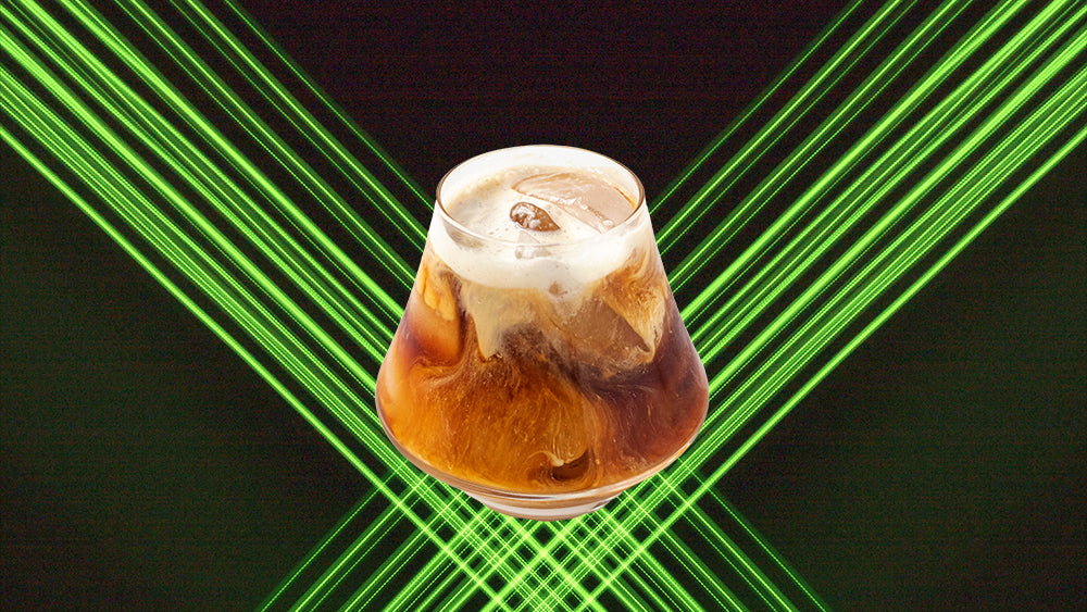 Green lasers behind a glass of cold brew coffee.