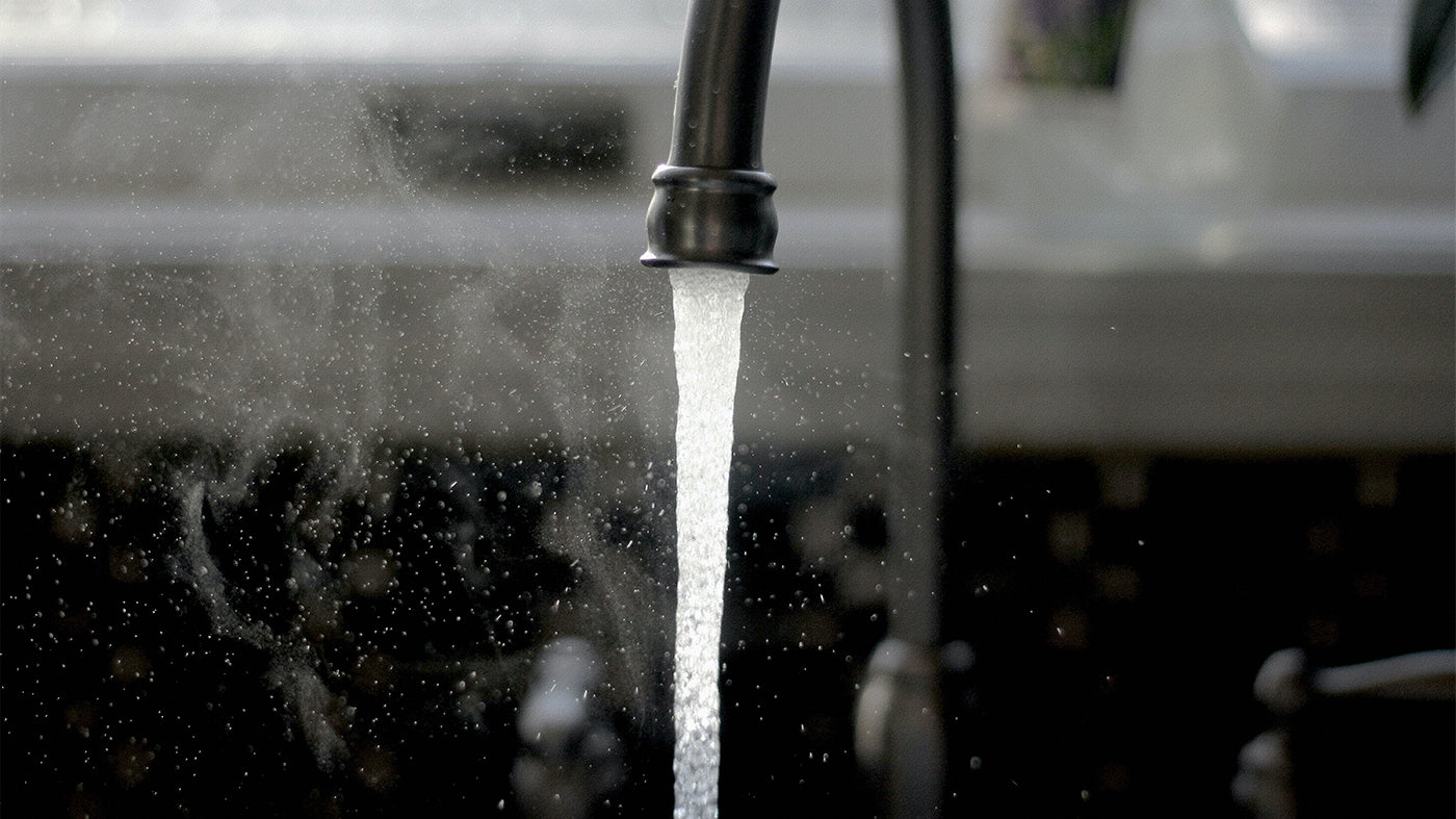 A kitchen faucet spouting water.