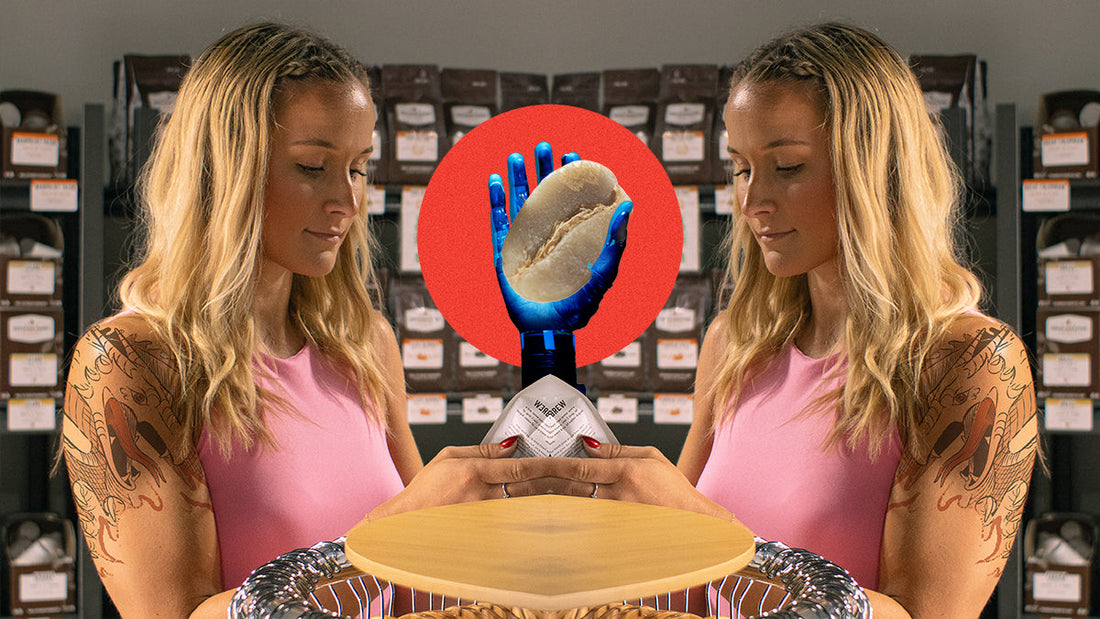 A mirror image of a woman with a Drago tattoo with a robotic arm in the middle, holding a green coffee bean against a red circle.