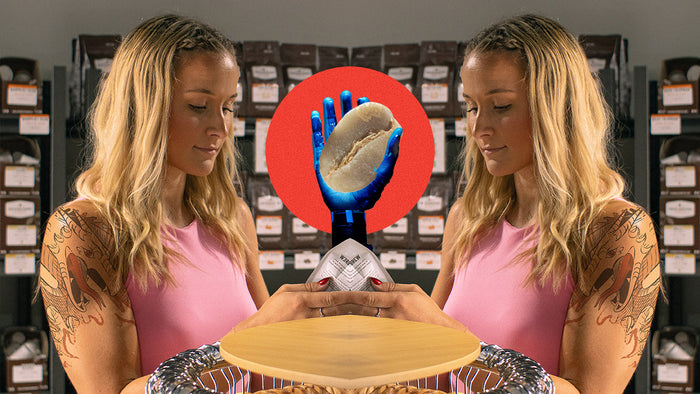 A mirror image of a woman with a Drago tattoo with a robotic arm in the middle, holding a green coffee bean against a red circle.