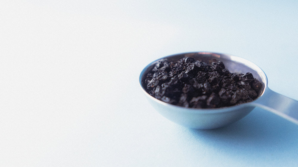 Macro photo of a tablespoon of dried elderberries.