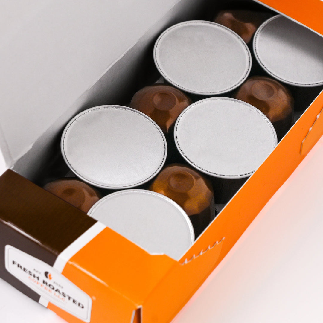 Masaccio espresso capsules from Fresh Roasted Coffee LLC neatly arranged in an open box, recyclable aluminum pods designed for Nespresso® OriginalLine machines.