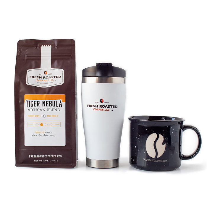 12 ounce bag of Tiger Nebula blend coffee, a white Fresh Roasted Coffee travel mug, and a black mug with etched FRC bean logo.